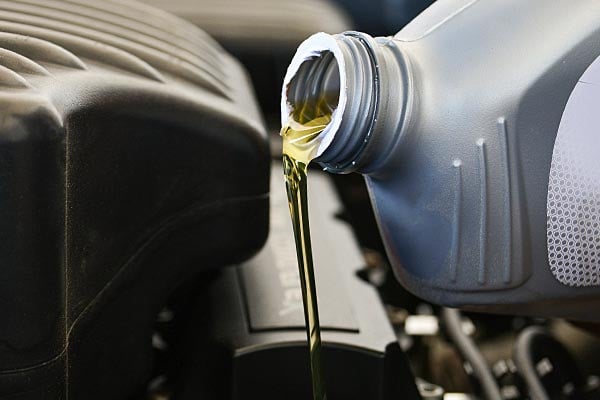 Motor oil being poured into an engine.