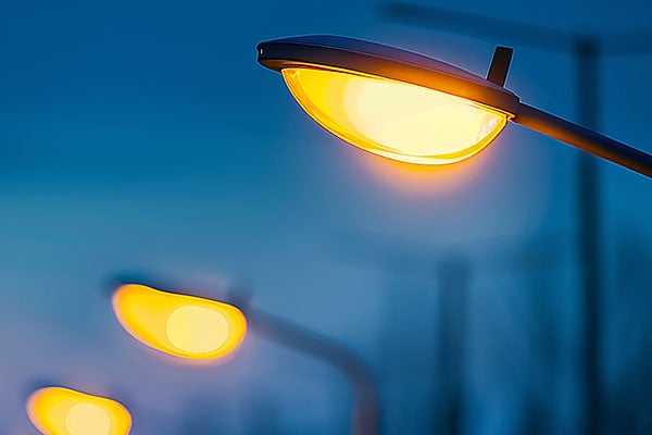 Closeup of streetlights at dusk.