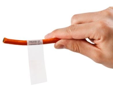 A self laminating label wrapped around an orange cable.