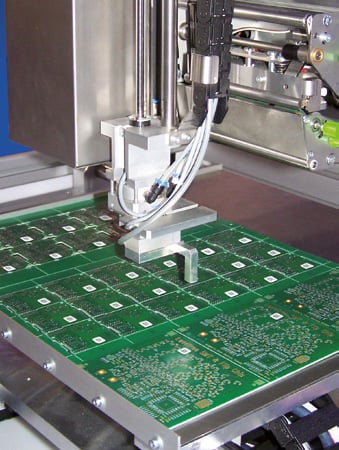 A green fabricated circuit board in a factory.