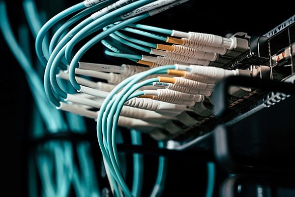 Blue fiberoptic cables connecting to networking equipment.