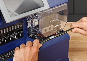 Employee uses the BradyPrinter A6500 Wrap Printer Applicator.