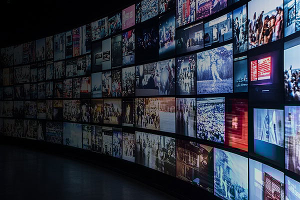 Curved wall of monitors with different images on each.