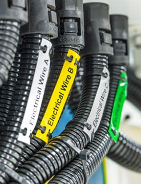 Closeup of Brady cable tags on gray hoses.