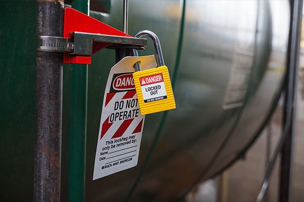  A safety lockout/tagout device is attached to a piece of industrial equipment, featuring a padlock and a DANGER DO NOT OPERATE tag.
