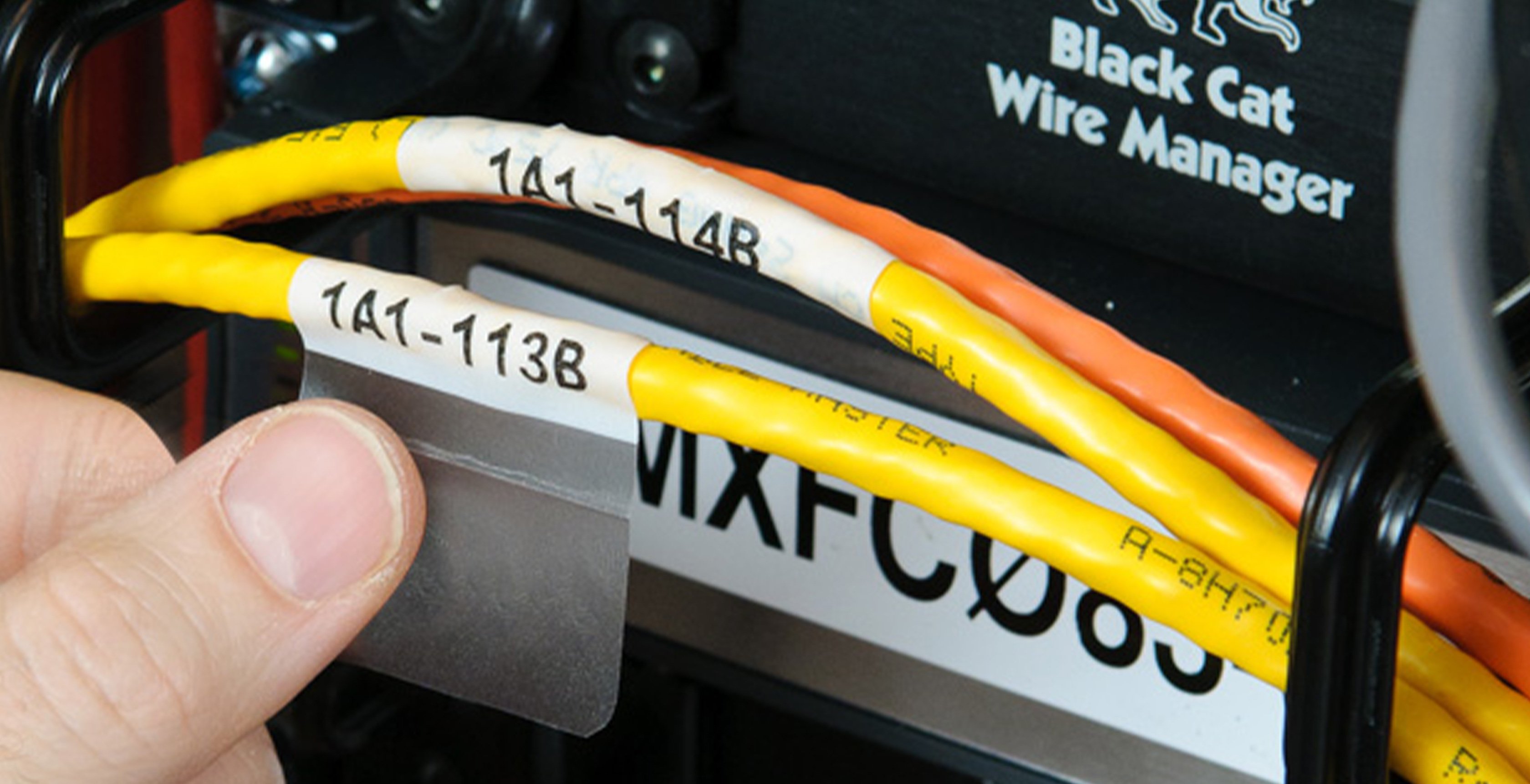 Self-laminating label applied to a yellow cable.