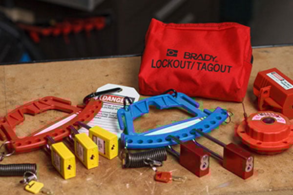 A collection of Brady Lockout/Tagout products, including a storage bag, safety padlocks, and various industrial lockout devices.
