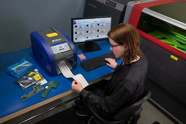 Woman at computer printing labels using a BradyPrinter i5300.