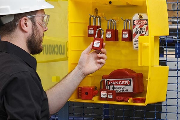 Man removing a lock from a lockout station.