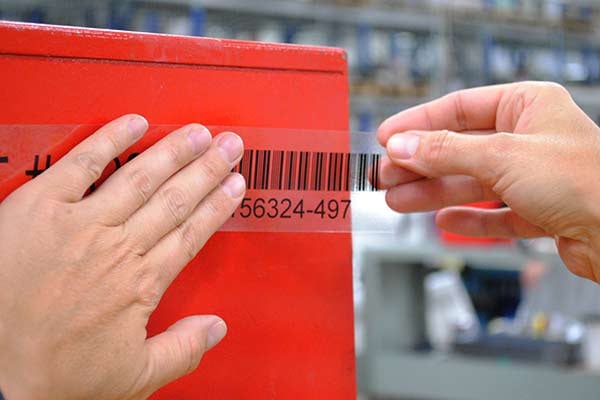 Brady clear transparent label material being applied to a metal surface