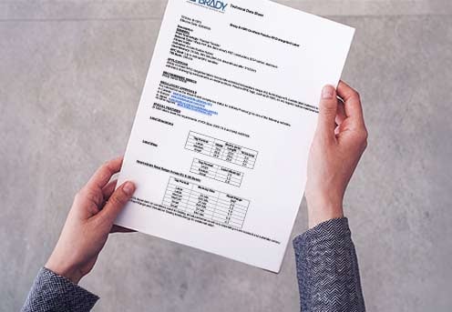hands holding a Brady technical data sheet 
