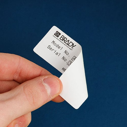 A hand peeling a label off a surface