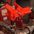 Red Brady ball valve lockout device with padlock attached.