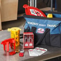 Brady lockout kit with padlocks, tags, valve lockout device, and other objects to complete a lockout task.