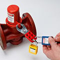 Person applying lockout padlocks to a Brady lockout hasp.
