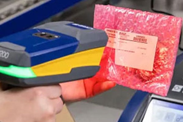 A person scanning a barcode with a Brady scanner