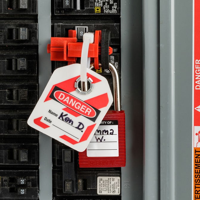 a lockout tagout tag and lock on an electrical panel