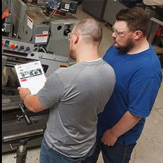 2 factory workers inspecting equipment