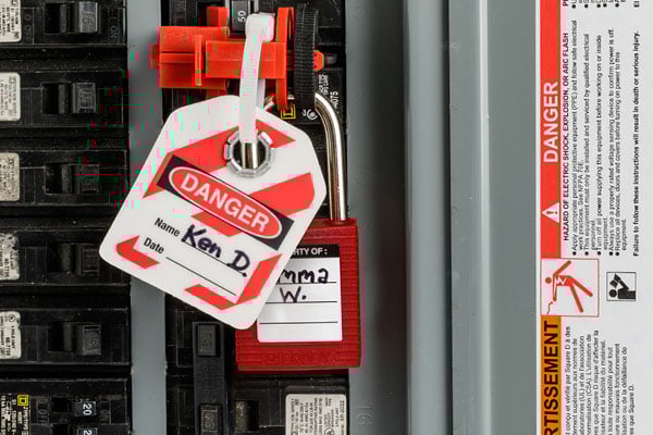 a lockout tagout tag and lock on an electrical panel