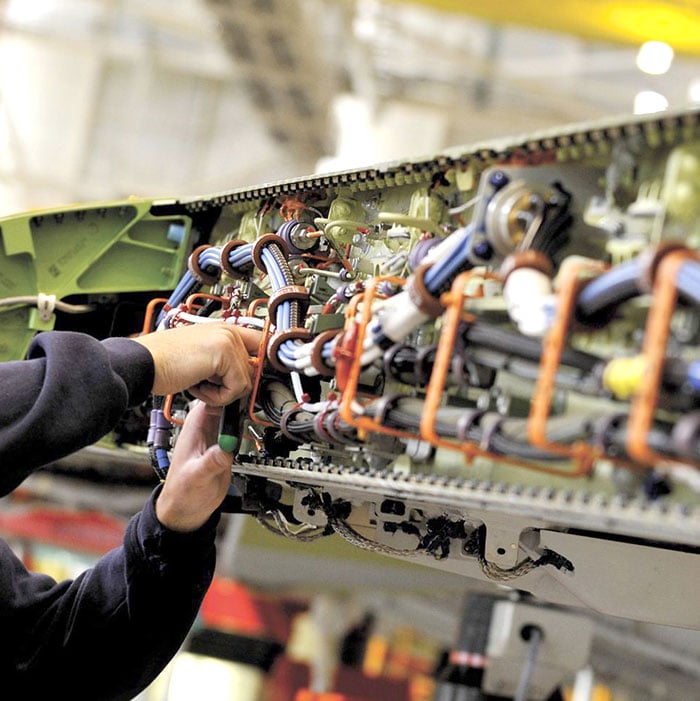 Person working on wiring for an aircraft