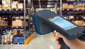 Person holding an RFID reader in a warehouse setting. 