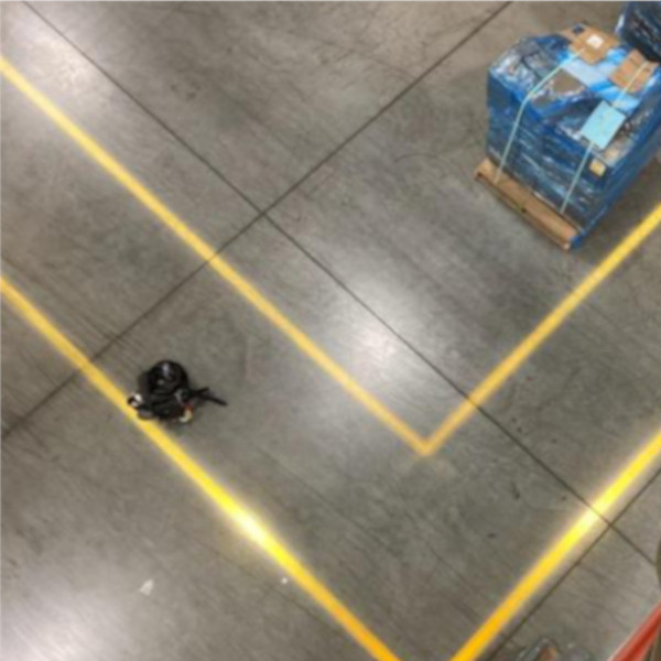 LED projected line on a warehouse floor, creating a pedestrian walkway.