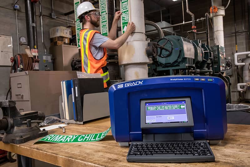 Close-up of a Brady S3700 printer being used to create labels for water supply pipes.