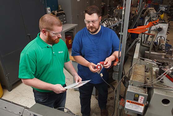 Two workers reviewing safety material.