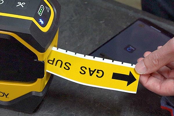 Brady label printer prints yellow gas line label with arrow.