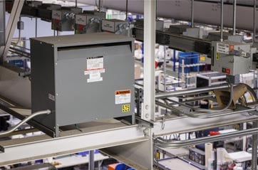 An electrical transformer in a warehouse or industrial facility.