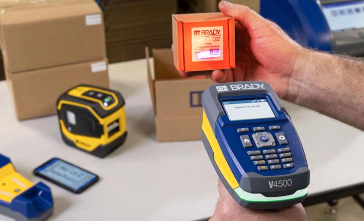 Worker uses a Brady V4500 handheld scanner to read a package label.  