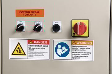 Electrical control panel with warnings and switches.