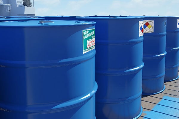 Blue drums with labels on a ship&#x27;s deck.