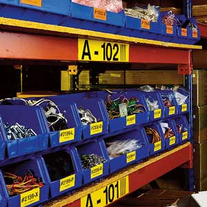 Shelving with blue storage bins, labeled with Brady warehouse labels.
