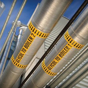 Industrial pipes with yellow safety labels.