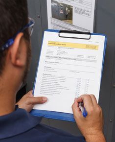A worker reviewing a checklist on a clipboard.