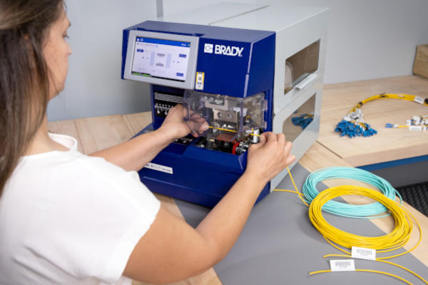 Employee creating cable flags for a data center using a Brady A5500 printer.