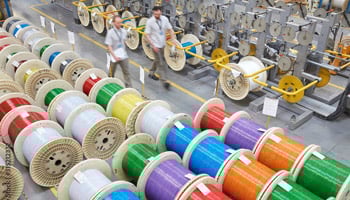 Spools of color-coded cable in a factory.