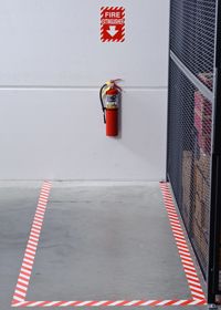 Red and white floor marking leading up to fire extinguisher.