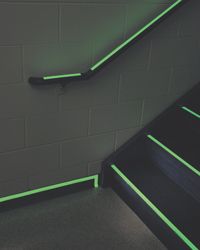 BradyGlo floor marking tape glows green in dimly lit stairwell.