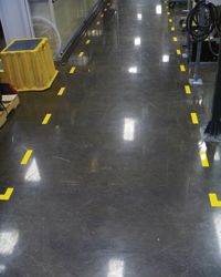 Intermittent yellow tape marks a hallway area in warehouse.