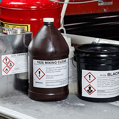 Bottles with GHS warning labels.