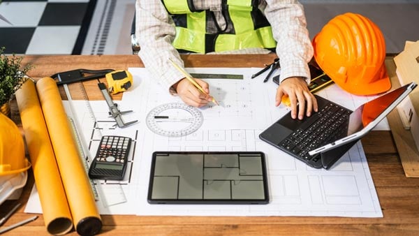 Architect or engineer drafting blueprints.