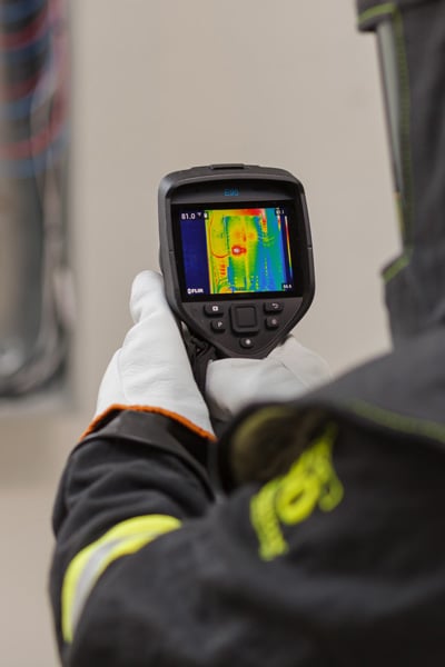 Brady service professional inspecting an electrical panel with a thermal camera.