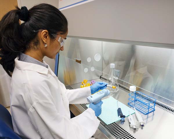 Technician labeling vials in a lab setting.