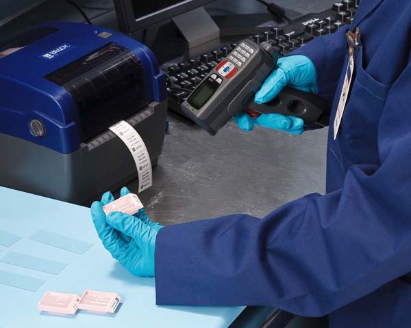 A lab tech scans labeled samples. 