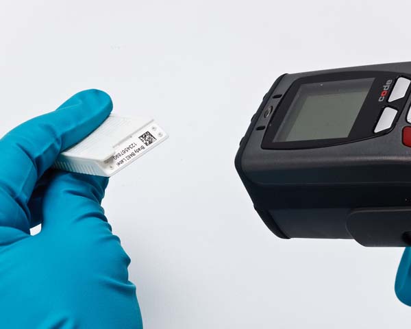 A lab tech uses a handheld scanner to scan labeled samples.