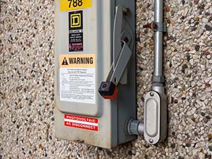 Electrical box with a lever and warning label on it. 