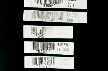Several white labels with barcodes, some smeared away, possibly wet.