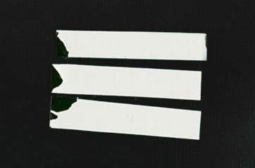 Three white, rectangular labels on a black surface.
